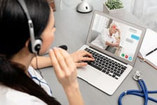 woman at laptop and talking on headset