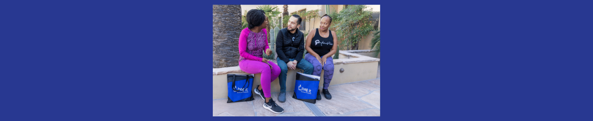 Photo of three people sitting on a bench talking